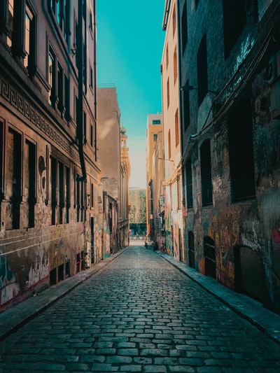 An empty street, between the concrete building during the day
